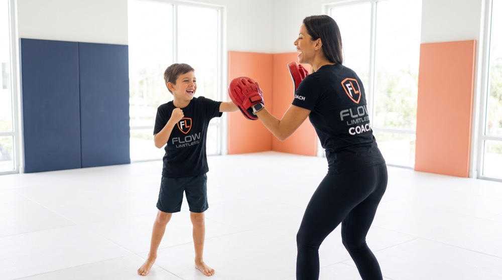 A young athlete works focus-mitt drills with Coach during a movement session